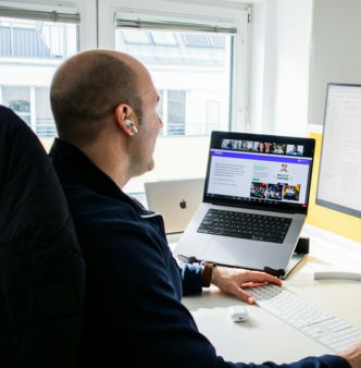 a man sitting in front of a computer monitor