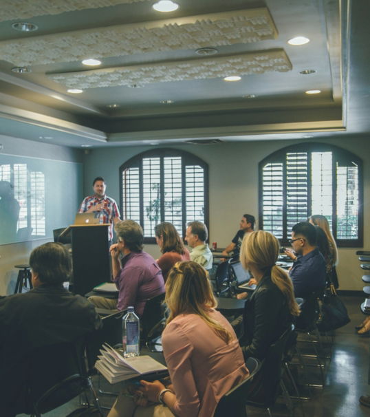a group of people in a room with a projector screen
